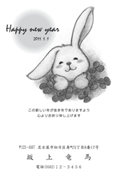 野原で笑顔で寝そべるうさぎの年賀状