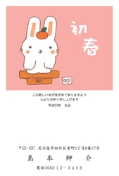 みかんを頭に載せて鏡餅になりきるかわいいうさぎの年賀状